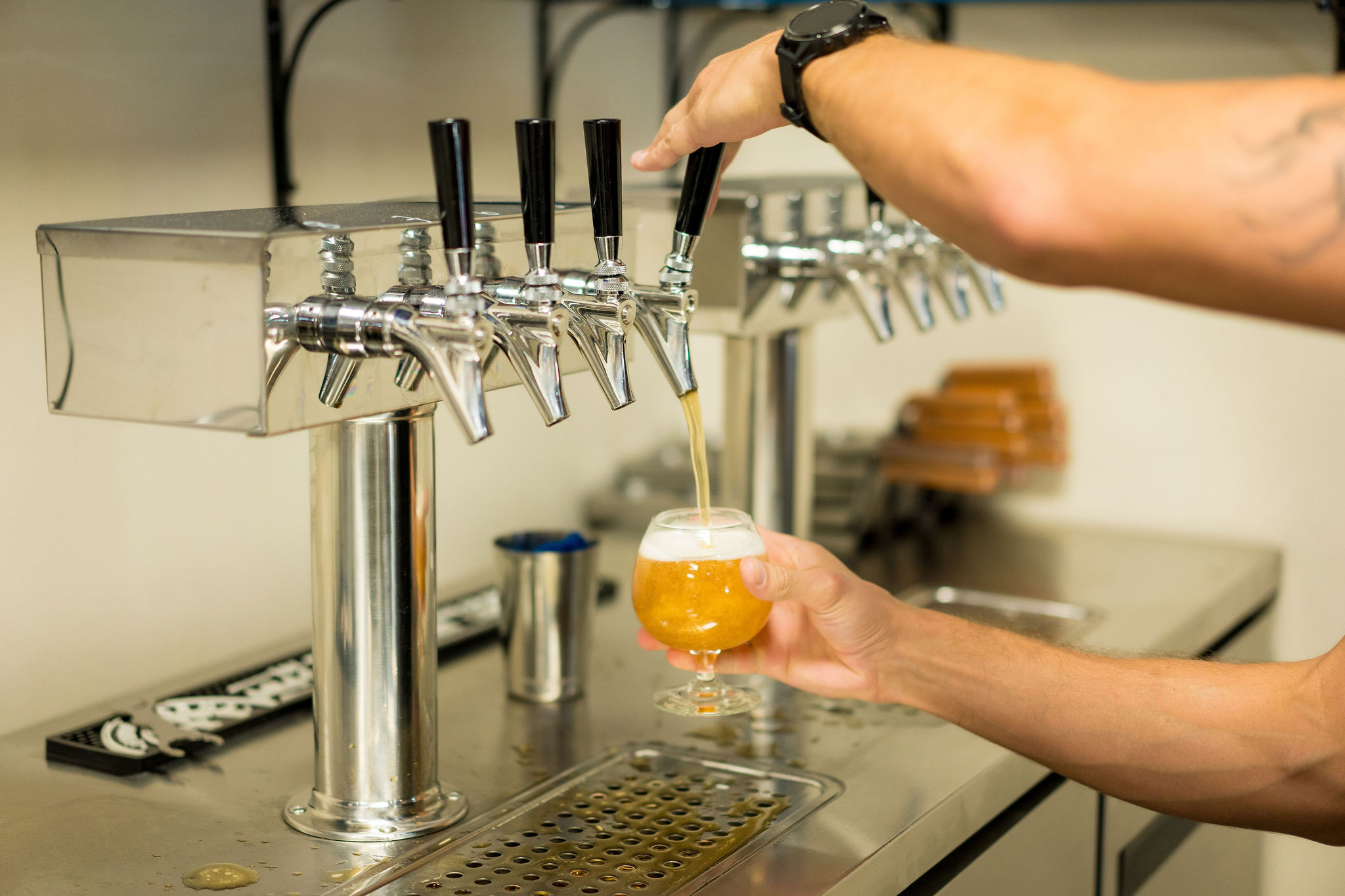 man pouring a craft beer from the tap at Brothers Beer and Bourbon